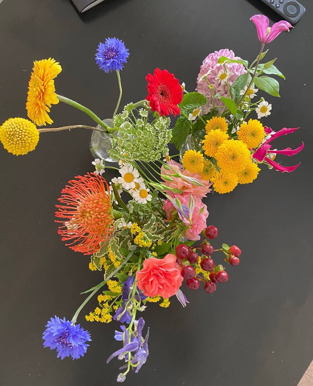 Loose colourful floral composition on a dark surface